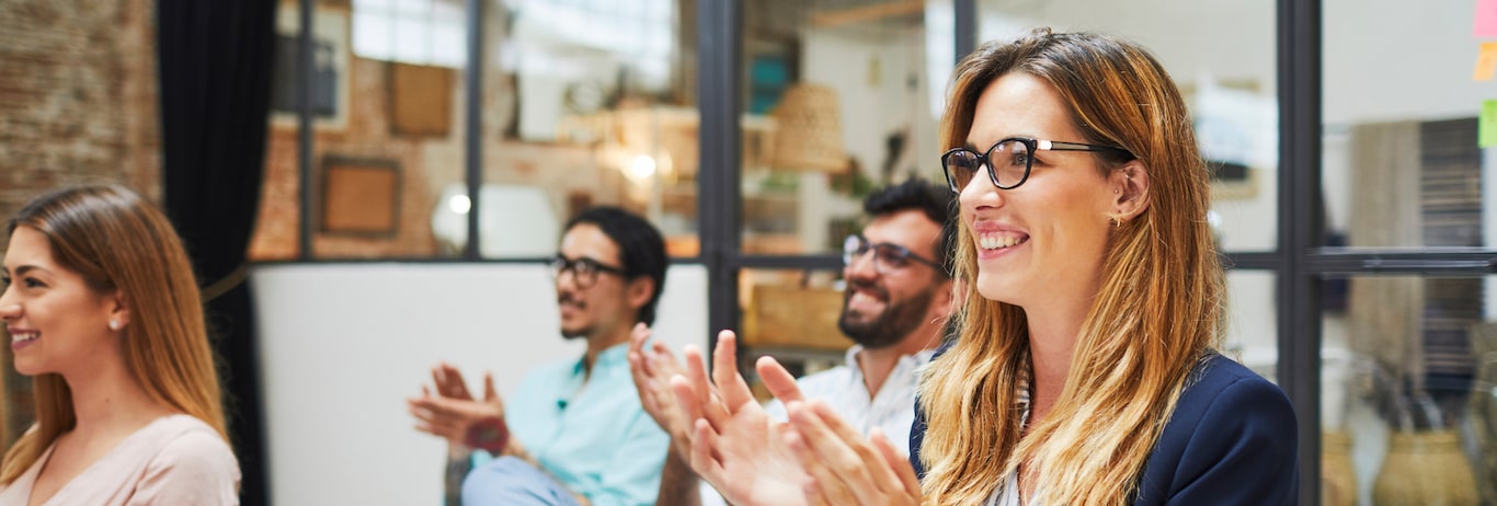 colegi de munca intr-o sala de sedinta asista la o prezentare