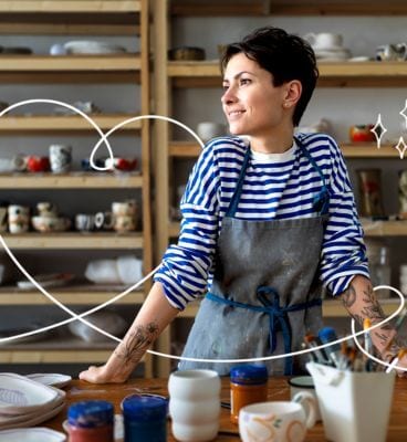 femeie tanara intr-un atelier de cermaica cu o bluza in dungi albastre