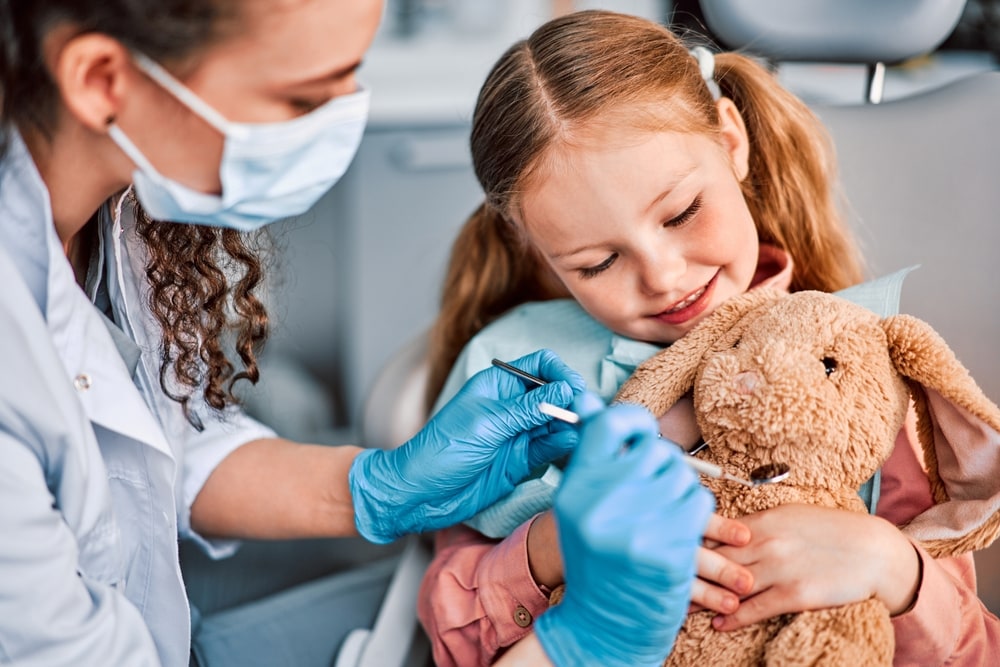 fetita cu dentist pediatru langa ea
