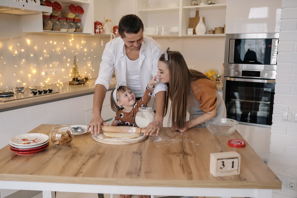 familie care intinde un aluat in bucatarie