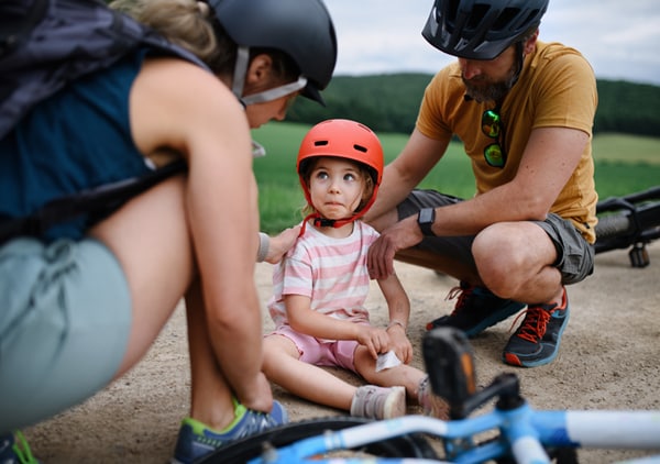 fetita accidentata pe bicicleta insotita de parinti care se gandesc la asigurarea NN