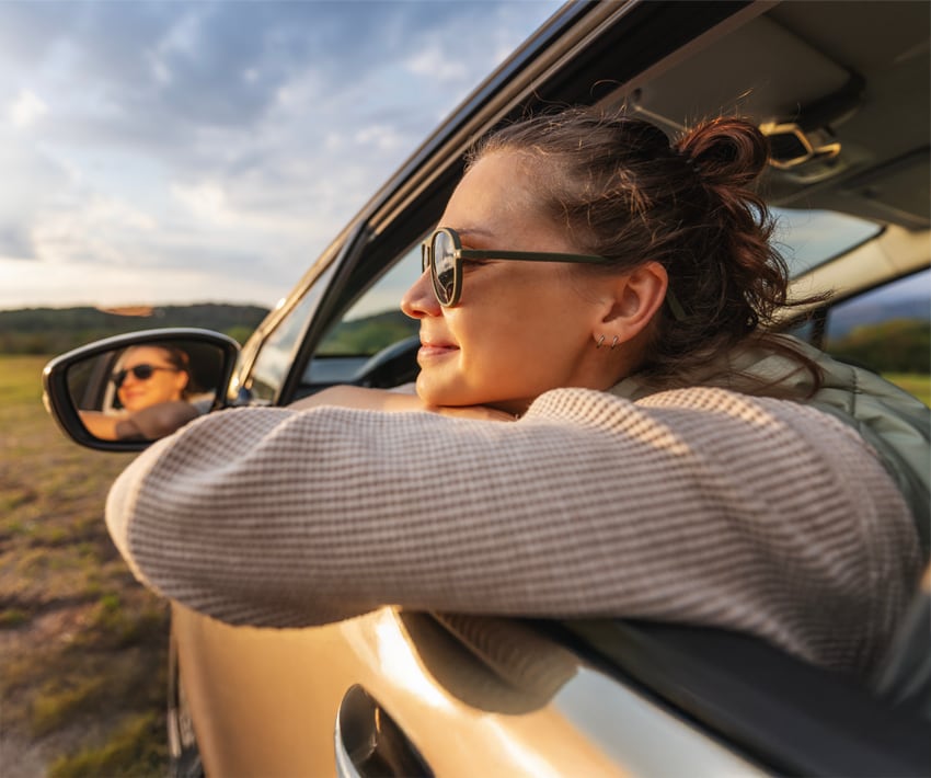 fata care priveste pe fereastra masinii si se gandeste ce bine este ca are asigurare nn