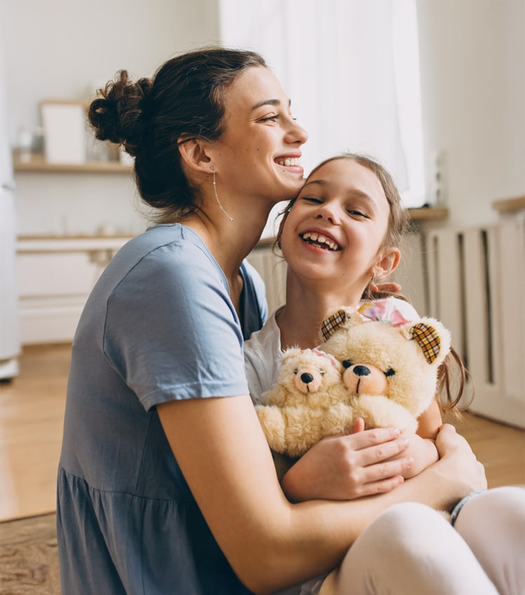 mama care isi tine fetita in brate protejata de asigurarea nn