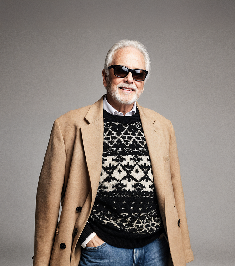 Un domn imbracat cu palton si care poarta ochelari NN