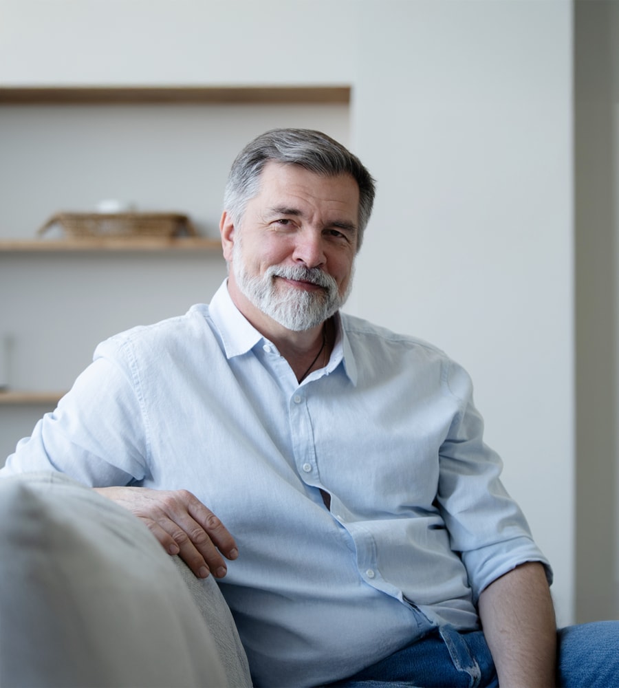 Barbat sta relaxat pe canapea si este protejat de asigurarea de viata Silver Care de la NN