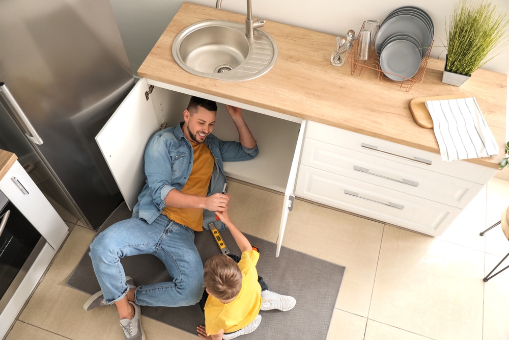 Barbat care repara chiuveta din bucatarie NN