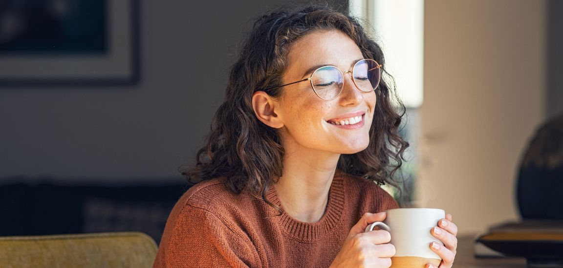 fata incerzatoare cu o cafea in mana