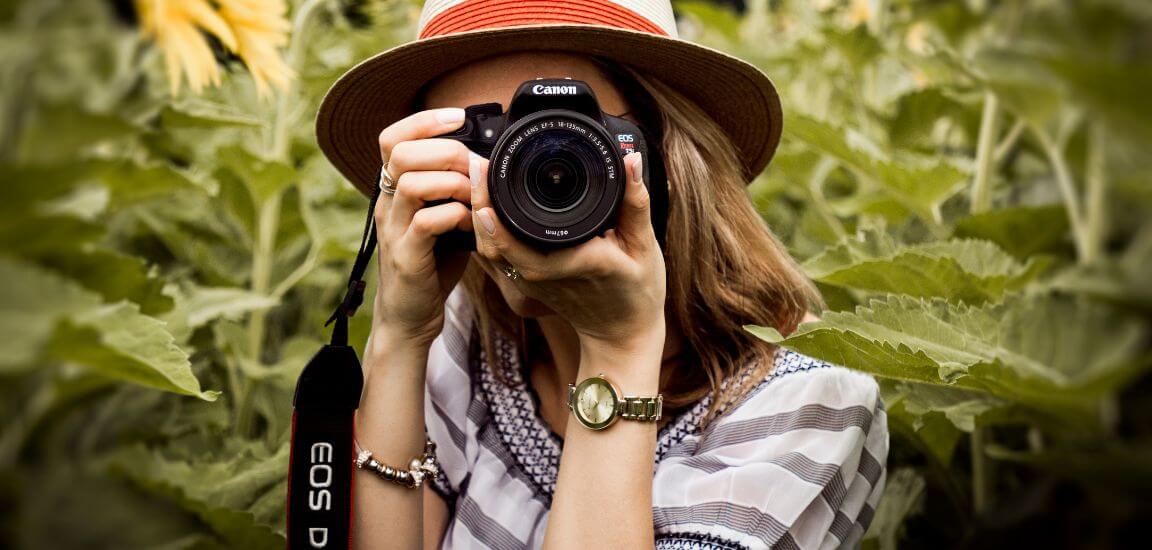 fata tine in mana un aparat foto profesionist si face o fotografie
