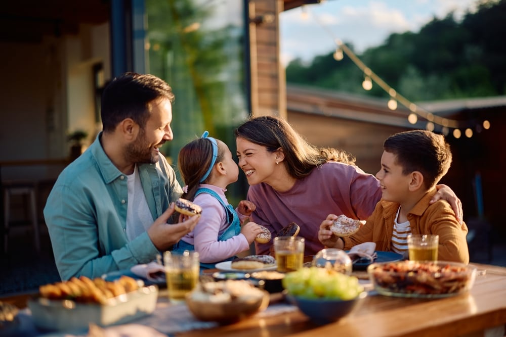 O familie fericita luand masa in gradina NN