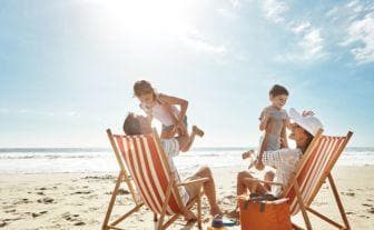 familie cu doi parinti si doi copii la mare
