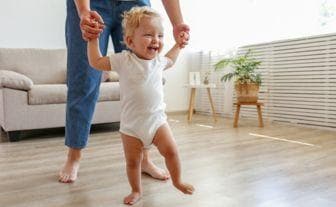 bebe care merge tinut de maini