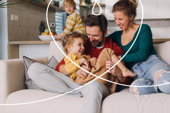 familie fericita pe canapea in living open space