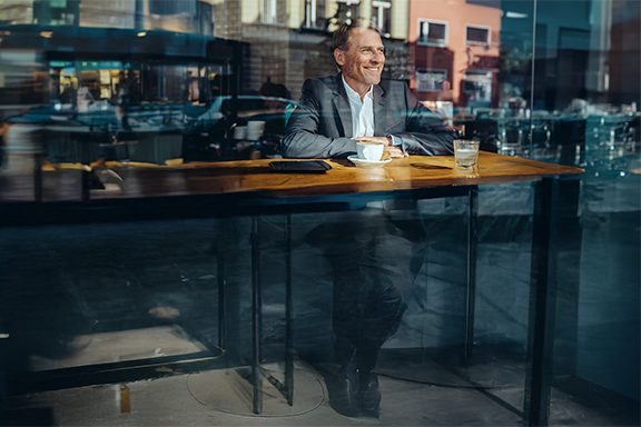 Barbat care zambeste intr-o cafenea NN mobile