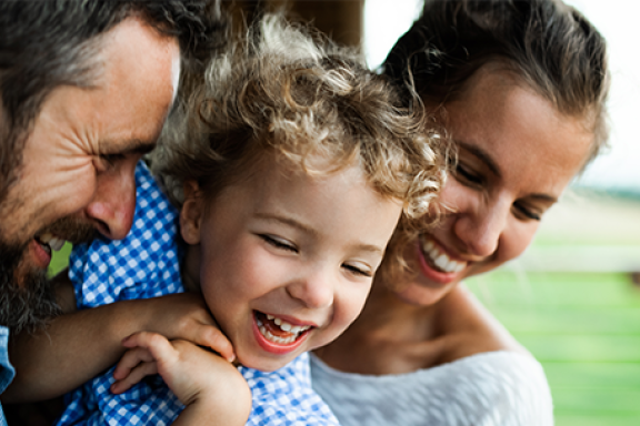 Parintii isi imbratiseaza copilul fericit NN mobile